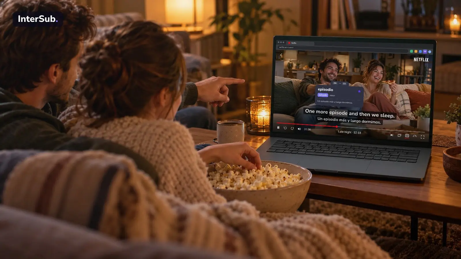 Two friends with popcorn watch a comedy on Netflix in the browser on a laptop, extensions in the toolbar, with English and Spanish subtitles; the InterSub dictionary shows “episode: episodio”